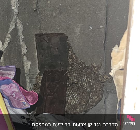 קיר בטון עם חפצים שונים, כולל חוטים וקרטון
